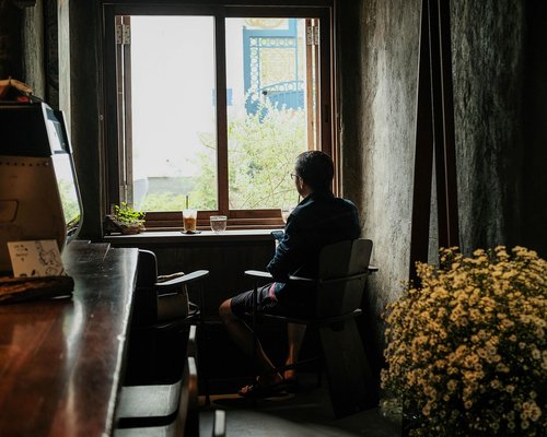 person looking out of the window resting eyes from laptop
